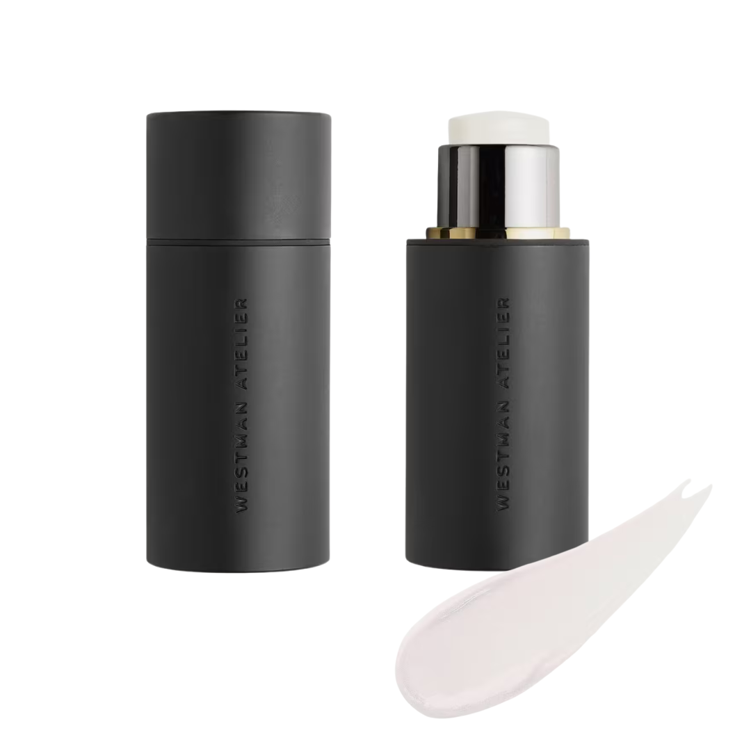 Black cosmetic stick with applicator and smear of cream on a white background, featuring the brand 'Westman Atelier'.